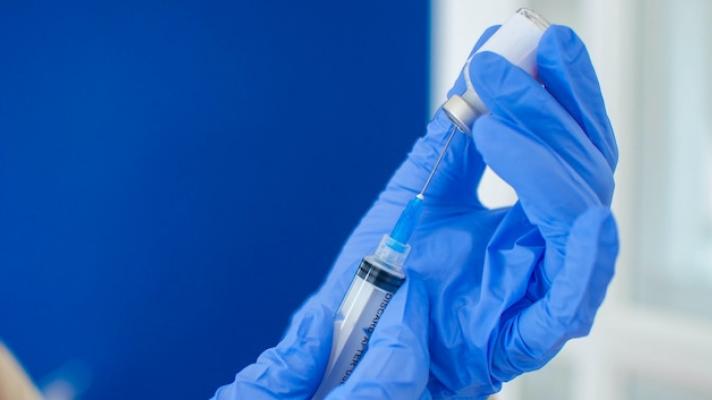 Doctor holding syringe and vial Photo by Karl Tapales/Getty Images